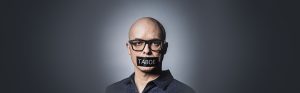 Portret van man met tape over de mond, op tape staat "taboe"