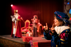 Sinterklaas op podium. gebarenpiet maakt gebaren