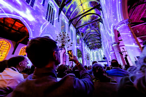 Verlichtte kerk met projecties in verschillende kleuren