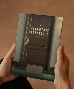 twee handen houden het boek ongewenst postadres vast