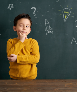 Klein kind kijkt bedenkelijk voor een schoolbord met tekeningen
