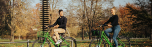 Man en vrouw op fietsen, fietsen door een park