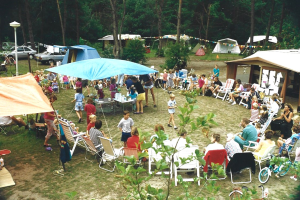 Oude foto van groep mensen aan het gebaren op de camping