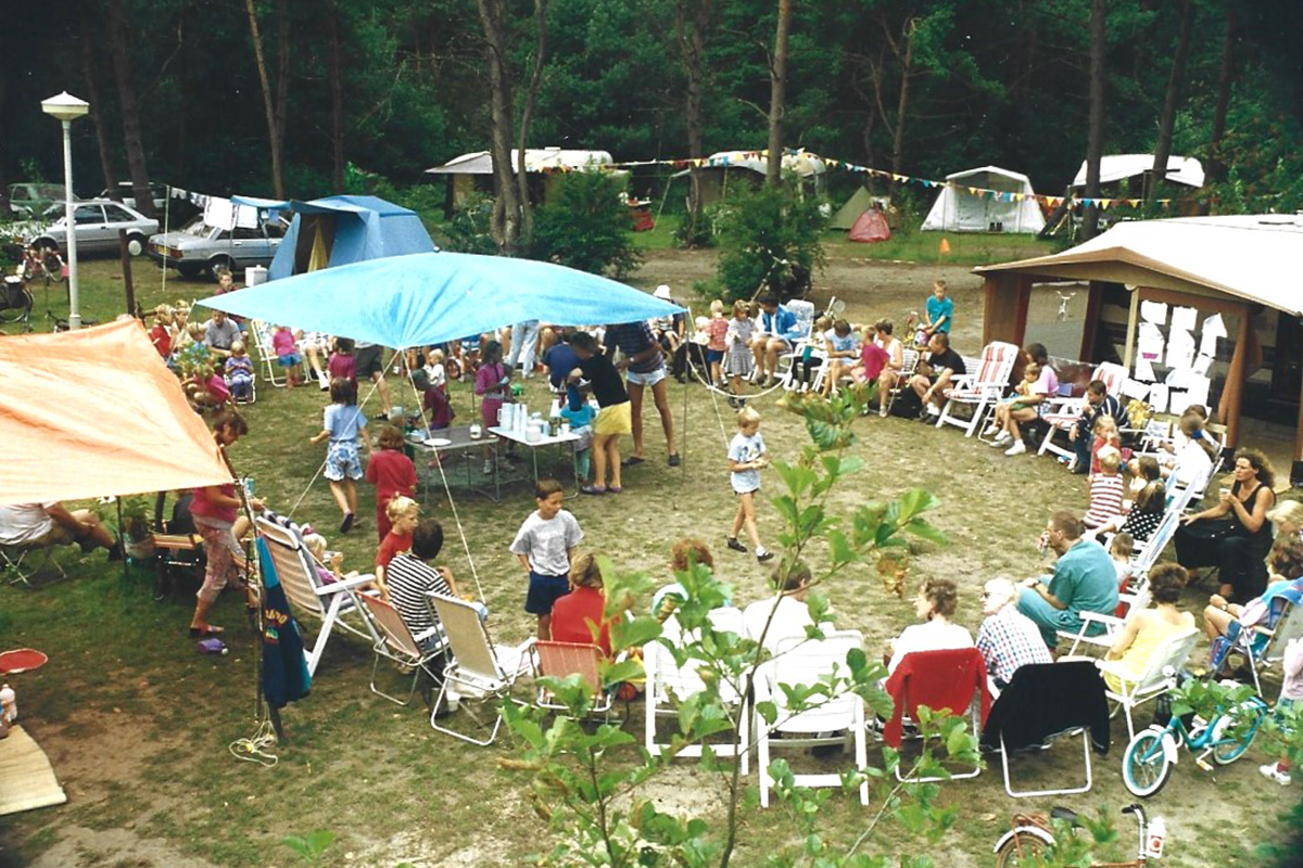 Oude foto van groep mensen aan het gebaren op de camping