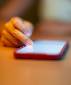 Mobiel op tafel en een hand die scrollt.