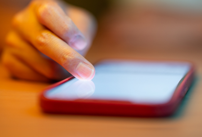 Mobiel op tafel en een hand die scrollt.