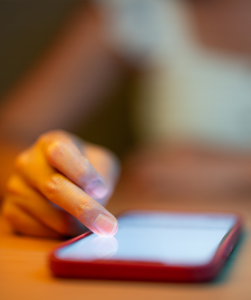 Mobiel op tafel en een hand die scrollt.