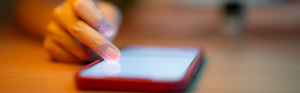 Mobiel op tafel en een hand die scrollt.