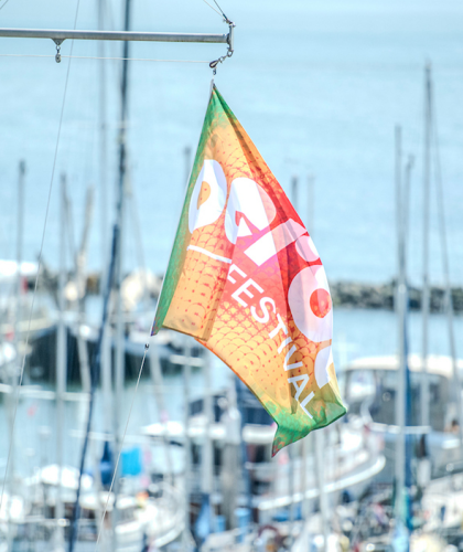 Wapperende vlag van Oerol in de haven van Terschelling