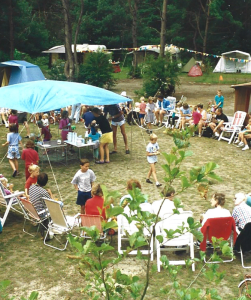 Oude foto van groep mensen aan het gebaren op de camping