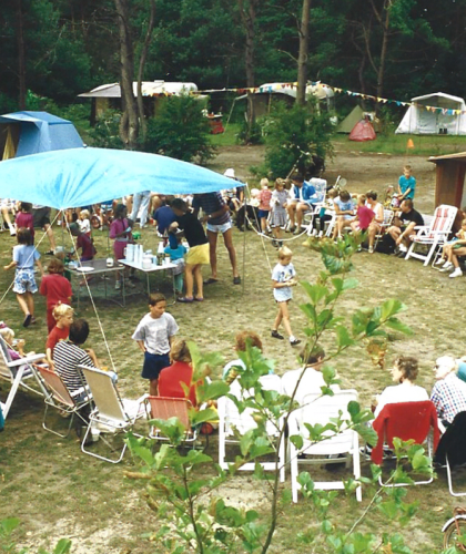 Oude foto van groep mensen aan het gebaren op de camping