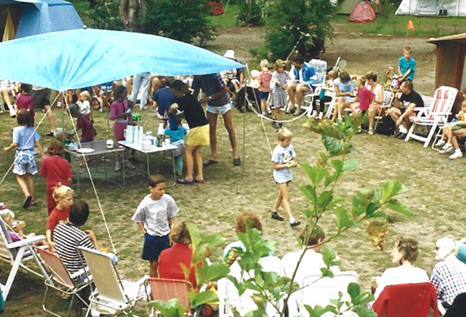 Oude foto van groep mensen aan het gebaren op de camping