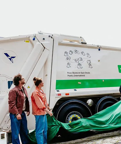 twee mensen naast vuilniswagen met gebaren