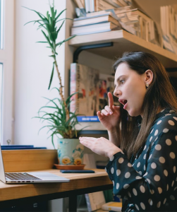 Vrouw kijkt naar laptop en maakt gebaren
