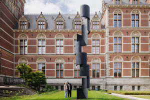 Twee mensen kijken naar een sculptuur van Carel Viseer in de tuin van het Rijksmuseum