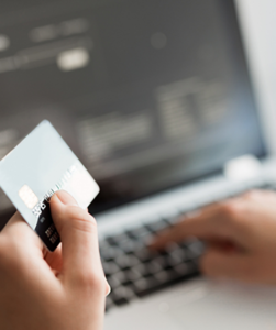 Een creditcard met laptop op de achtergrond