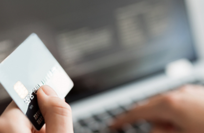 Een creditcard met laptop op de achtergrond