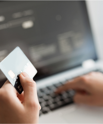 Een creditcard met laptop op de achtergrond